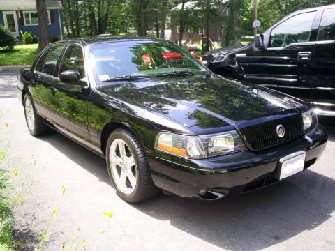 2003 Mercury Marauder - A black 2003 Mercury Marauder sedan is parked on a street, with another black vehicle behind it.