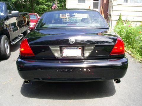 2003 Mercury Marauder - The rear of a black Mercury Marauder is shown, parked in a driveway with a pickup truck beside it.
