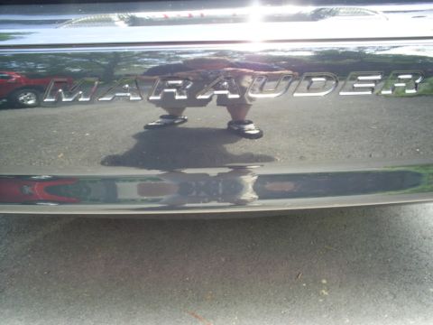 2003 Mercury Marauder - The Marauder emblem is visible on the trunk of a car, with a reflection of a person and another vehicle.