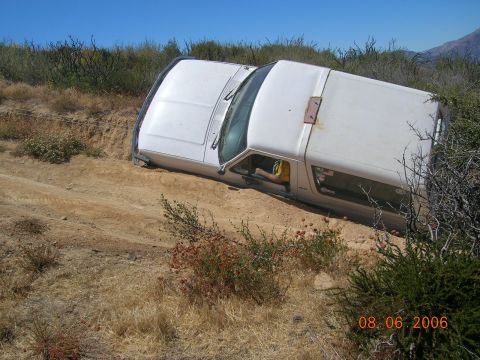 1985 Ford Bronco - White 1985 Ford Bronco is stuck on a dirt embankment off-road.