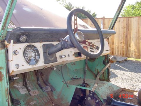 1991 Ford Explorer - The interior of a vintage vehicle shows significant rust and wear on the dashboard, steering wheel, and floor pedals.