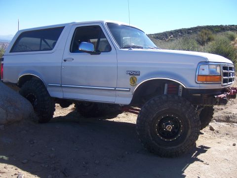 1985 Ford Bronco - This modified Ford Bronco is shown off-roading on a sunny day.