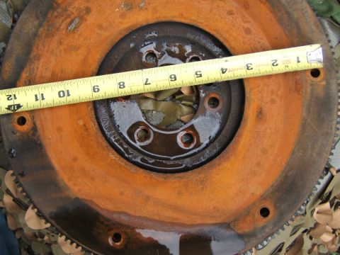 1980 Jeep CJ5 - Close-up of a heavily rusted flywheel with a tape measure laid across it.