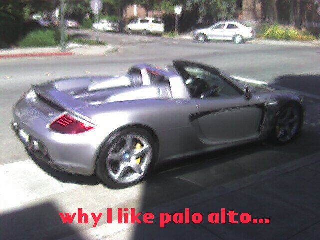 Silver Porsche Carrera GT convertible parked at a curb on a residential street