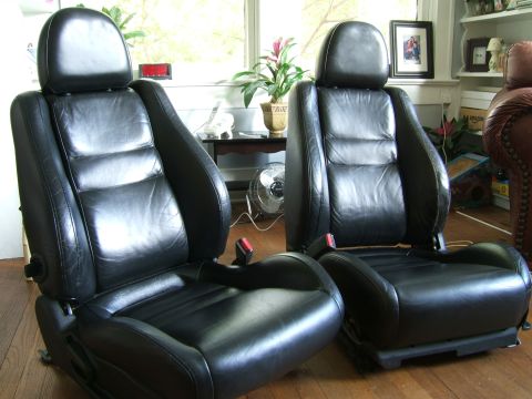 1996 Ford Probe - Two black leather car seats are shown indoors, likely removed from a vehicle.