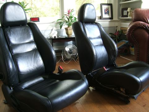 1996 Ford Probe - Two black leather car seats are shown indoors, likely for sale or replacement.