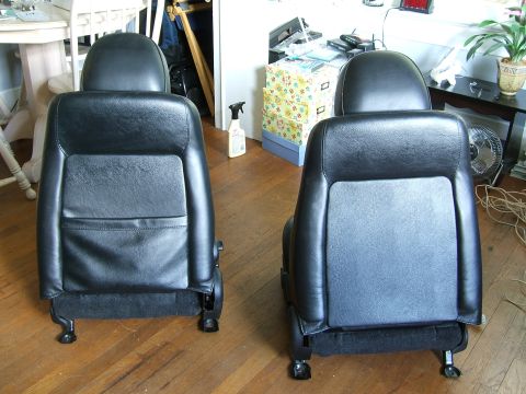 1996 Ford Probe - A pair of black leather car seats are shown, likely for a sports car, with visible seat rails and headrests.