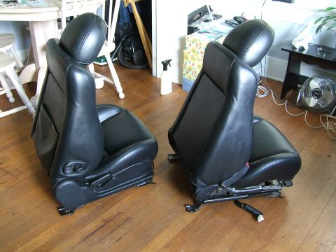 1996 Ford Probe - Two car seats are shown removed from a vehicle, resting on a hardwood floor.