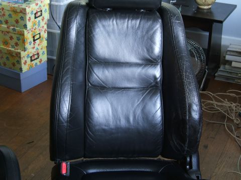 1996 Ford Probe - A close-up of a worn black leather car seat, showing stitching detail and some cracking on the bolster.