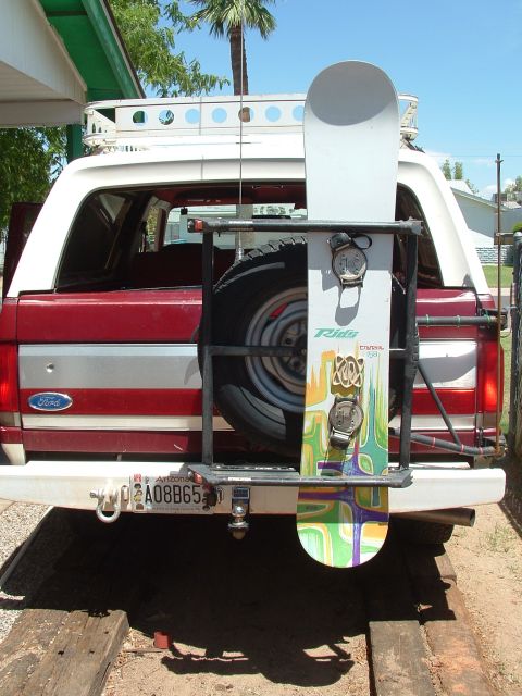 1990 Ford Bronco - Rear view of a 1990 Ford Bronco equipped with a snowboard carrier and spare tire.