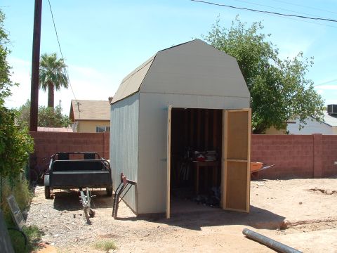 1990 Ford Bronco - A trailer sits beside an open shed in a dry, outdoor setting.