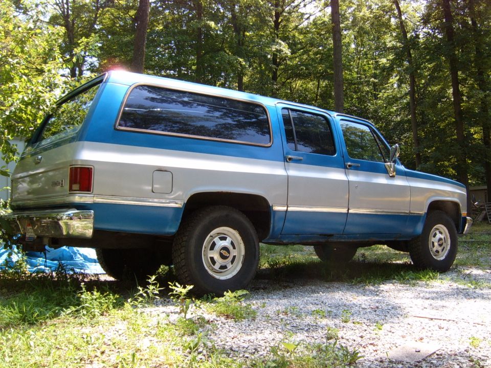 Blue and silver two-tone SUV parked outdoors with trees in the background