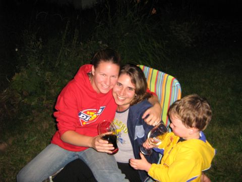 1995 Ford Bronco - Three people enjoy drinks outdoors at night, seated in a striped chair.