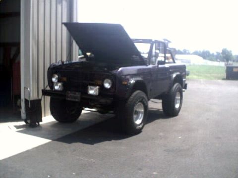 1996 Ford Bronco - This Ford Bronco is parked outside a garage with its hood up, showing off its engine bay.