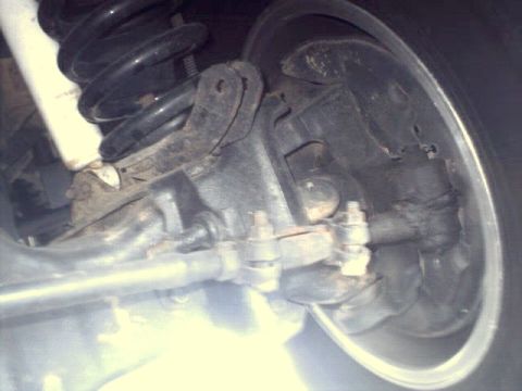1996 Ford Bronco - Detail of the front suspension and brake components of a vehicle, with visible text from Supermotors.net.