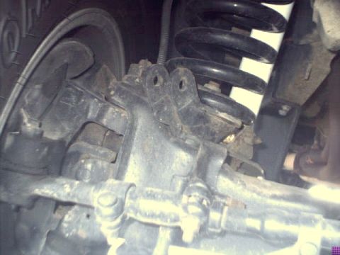 1996 Ford Bronco - Detail shot of the front suspension system and tire, with a Supermotors watermark visible at the bottom right.