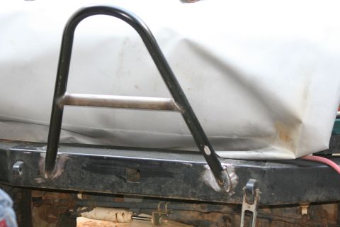 1996 Ford Bronco - Close-up of a custom bumper and roll bar, with a white tarp in the background and "Supermotors.net" visible.