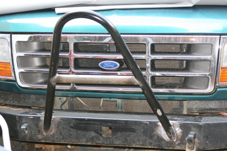 Teal Ford front grille with Ford oval and black U-shaped tubular bar on bumper