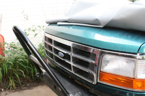 1996 Ford Bronco - Front view of a green Ford truck a chrome grille and an aftermarket bumper.