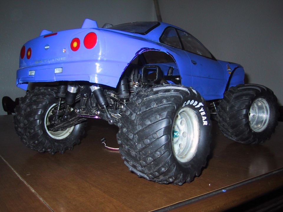 Blue RC monster truck with large tires, modified body, and visible suspension