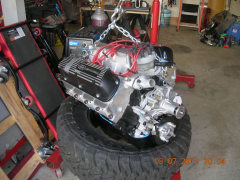 1996 Ford Bronco - Engine with Ford Racing valve covers is being worked on in a garage.