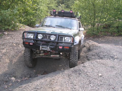 1992 Ford Bronco - This modified Jeep Cherokee XJ navigates a challenging off-road terrain with its tires and winch system.