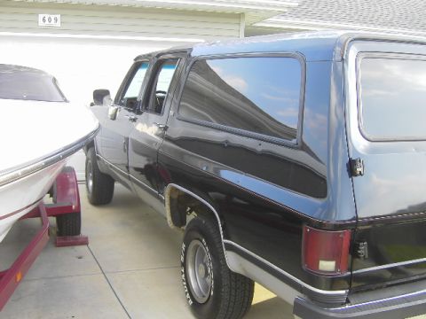1990 Chevrolet Suburban - This 1990 Chevrolet Suburban is parked next to a boat on a trailer.
