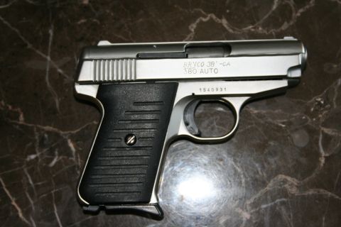 2004 Jeep TJ - A close-up view of a Bryco 380 Auto pistol, showing its silver slide and black grip.
