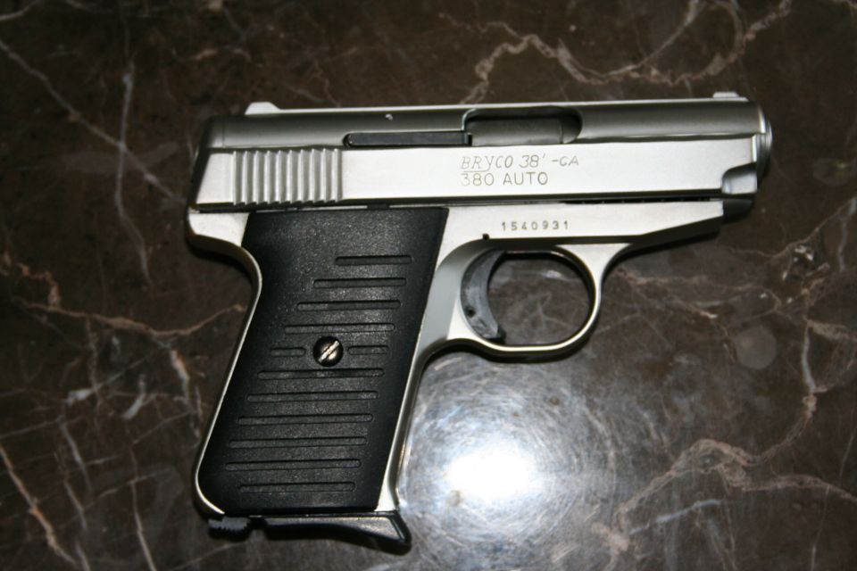 Bryco 380 Auto pistol on marble surface. Serial number 1540931 visible