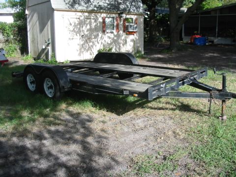 1997 Ford Crown Victoria - A car hauler trailer is shown parked outdoors on a grassy area, with a shed in the background.