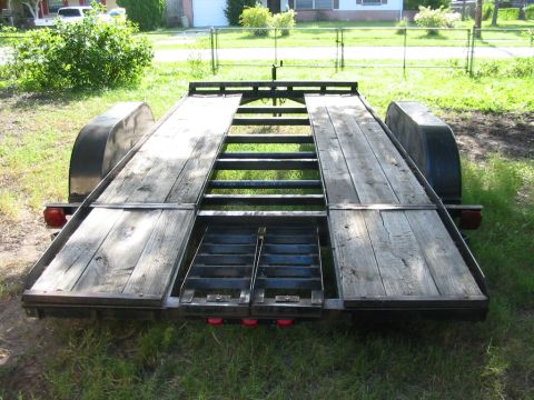 1997 Ford Crown Victoria - Rear view of a car hauler trailer a wooden deck and metal ramps, with a "Supermotors.net" watermark.