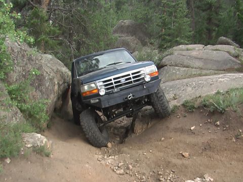 1981 Ford Bronco - Ford Bronco tackling an off-road obstacle course with large rocks.
