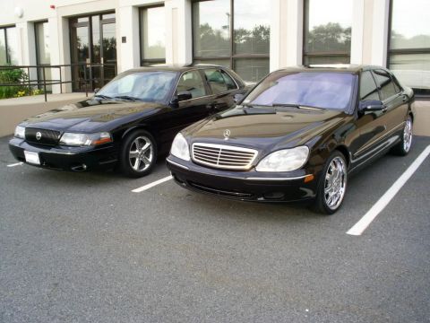 2003 Mercury Marauder - Two black sedans, a 2003 Mercury Marauder and a Mercedes-Benz S-Class, are parked in a lot.