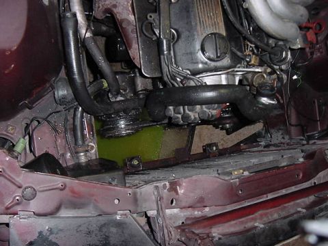 1984 BMW 3 Series - Leaking green coolant is visible in the engine bay, pooling near the engine block and hoses.