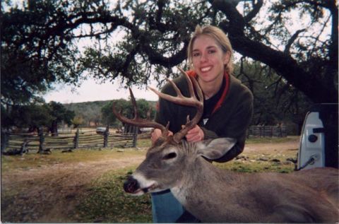 1986 Ford Bronco - A woman poses with a harvested deer, its impressive antlers prominently displayed.