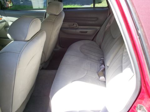 1995 Ford Crown Victoria - Interior view of a car's back seat and door panel, showing light-colored upholstery and trim.