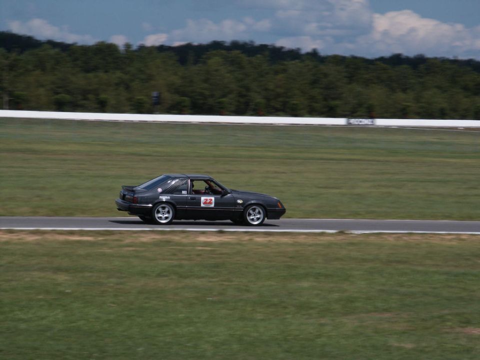 Black coupe with racing number 22 on side, on a racetrack