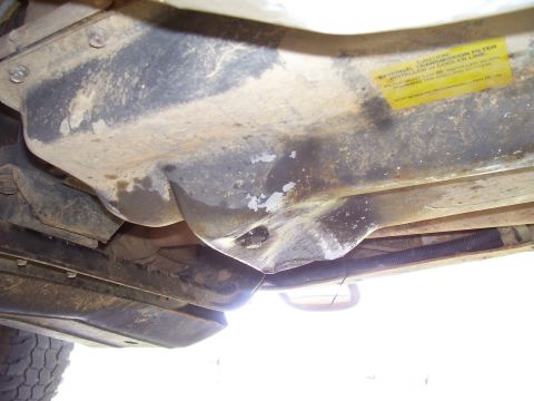 1992 Ford Bronco - Underside view of a vehicle, showing a component with a yellow warning sticker attached.