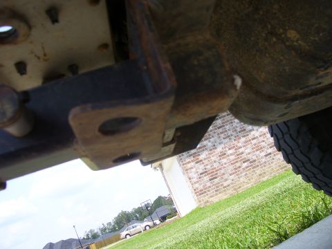 1992 Ford Bronco - Close-up view of the underside of a vehicle's frame, showing a tow hitch bracket and a tire.