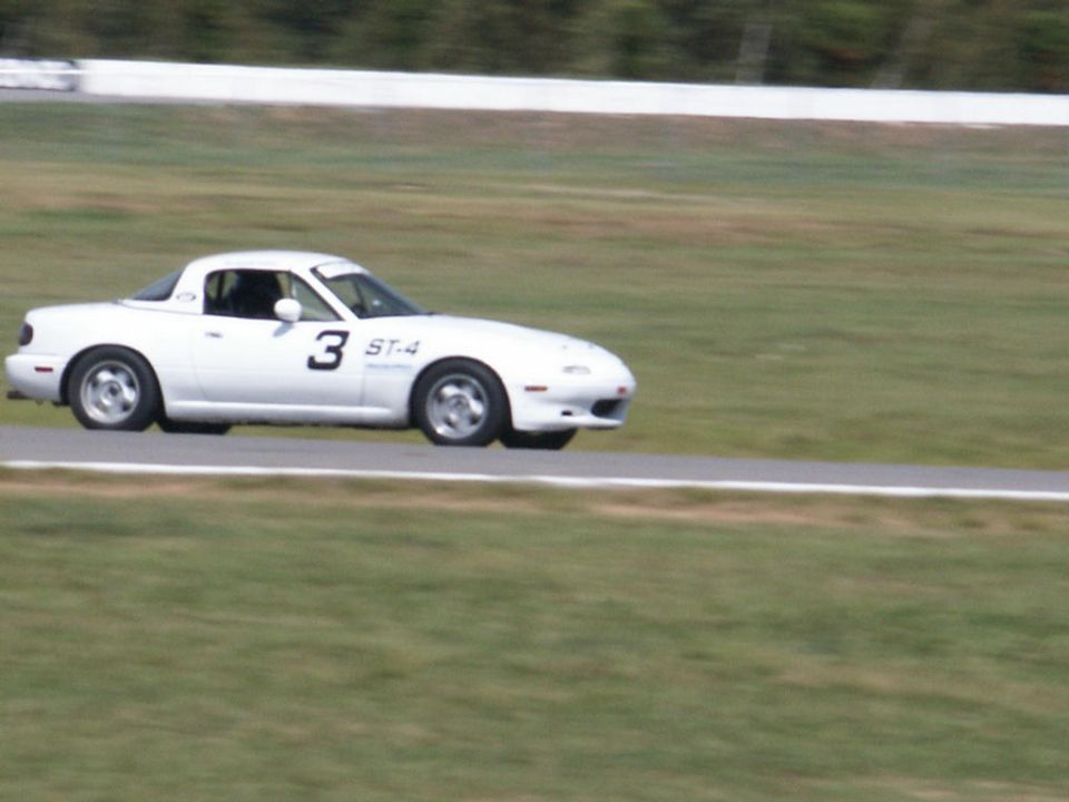 White Miata hardtop race car number 3 ST-4 at speed on road course