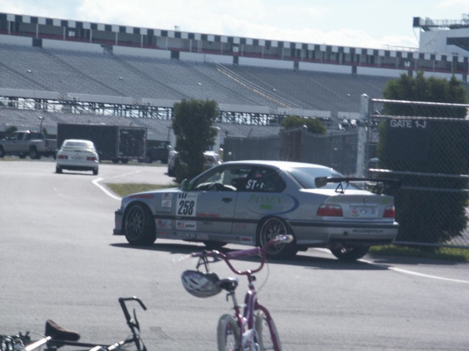 Silver coupe with racing decals and spoiler on track