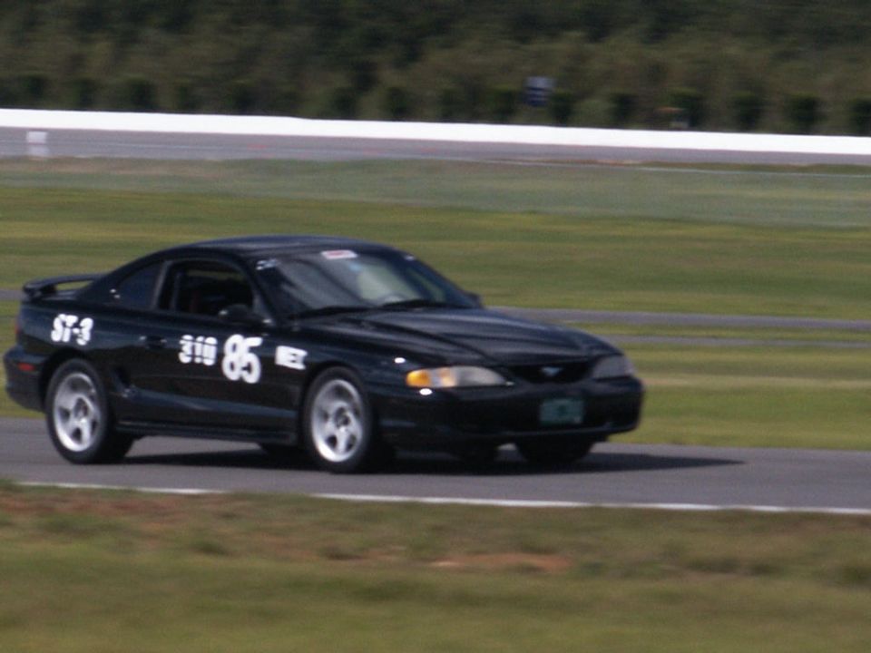 Black SN95 Mustang number 85 ST-3 road racing on track