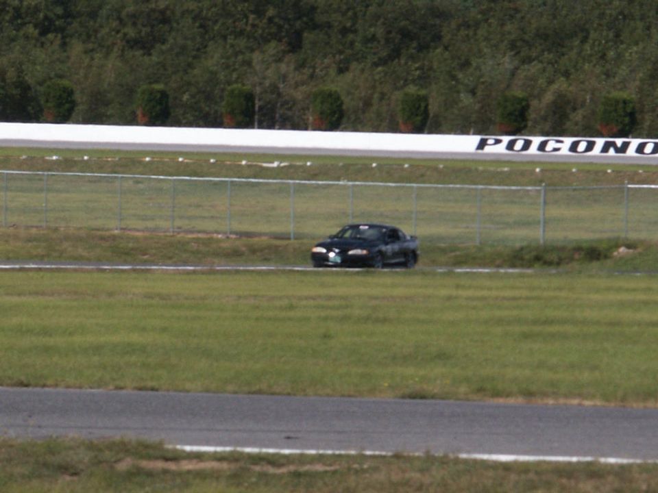 Black sedan on a race track with 'Pocono' visible on the wall