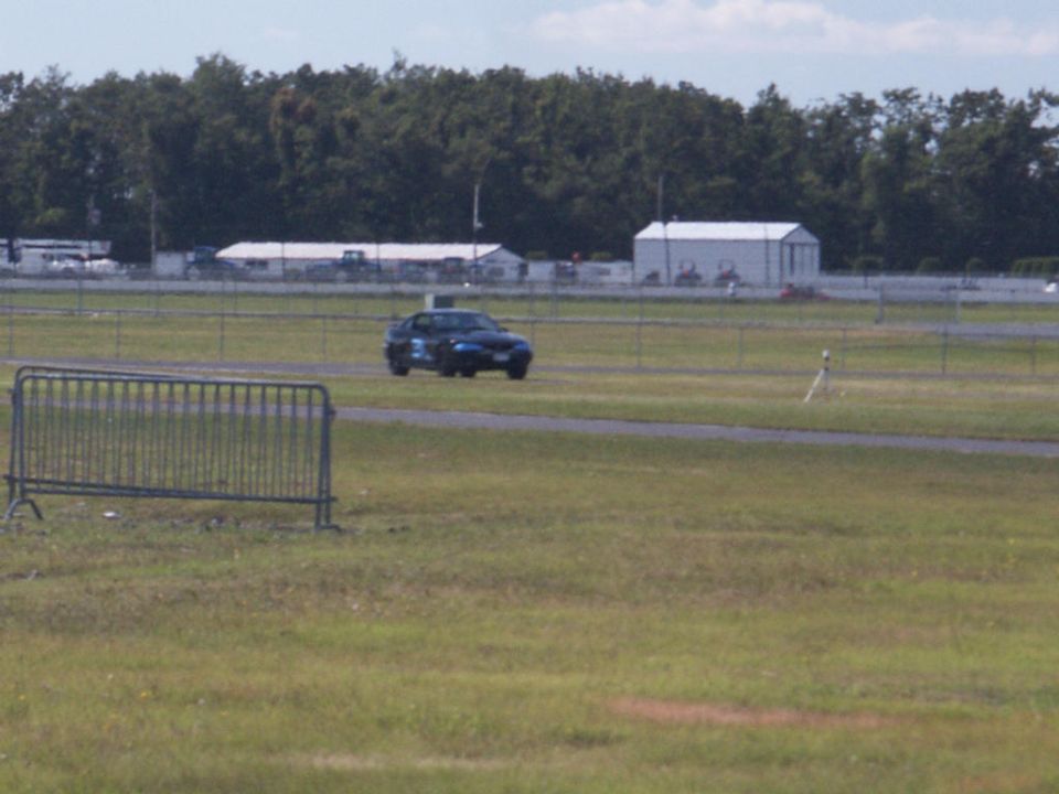 Blue sedan on a race track, 3q-front view