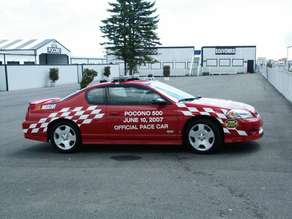 Red Chevrolet Monte Carlo with checkered flag graphics and 'Pocono 500 June 10, 2007 Official Pace Car' text
