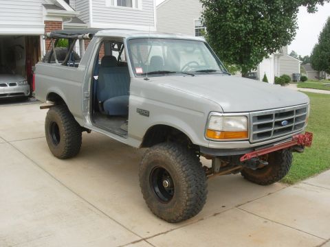 1995 Ford Bronco - This 1995 Ford Bronco features a doorless modification and is equipped with large off-road tires for enhanced capability.