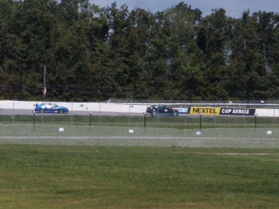 Two race cars on a track with a NEXTEL CUP SERIES banner