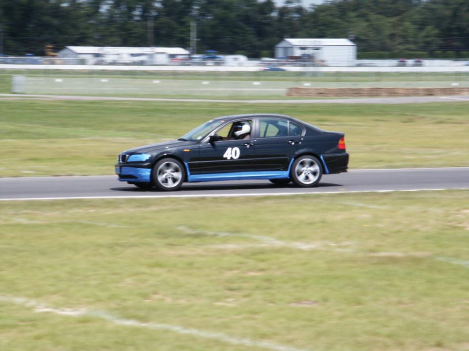 Black sedan with blue trim and number 40 on door driving on a race track