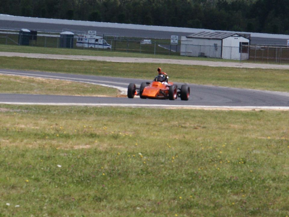 Orange open-wheel race car on a track