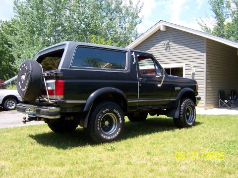 1987 Ford Bronco - This 1987 Ford Bronco is shown from the rear three-quarter view, parked outside a residential garage.